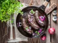 Smażona kaszanka z cebulą na patelni, idealna na keto. Świeża natka pietruszki dodaje aromatu.