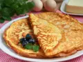 Złociste keto naleśniki bez mąki, ozdobione borówkami i miętą, kuszą swoim wyglądem.