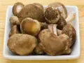 Świeże grzyby shiitake w białej misce, idealne na keto dietę.