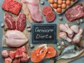 Różnorodne mięsa, ryby i jaja na stole. Tabliczka z napisem "Carnivore Dieta" sugeruje inspiracje kulinarne dla tej diety.
