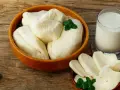 Ser halloumi w ciąży: świeży ser i szklanka mleka na drewnianym stole. Idealne dla przyszłej mamy.