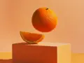 Pomarańcze na keto – soczysty plasterek na pomarańczowym sześcianie, a nad nim lewitująca cała pomarańcza.