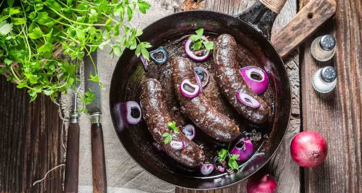 Smażona kaszanka z cebulą na patelni, idealna na keto. Świeża natka pietruszki dodaje aromatu.