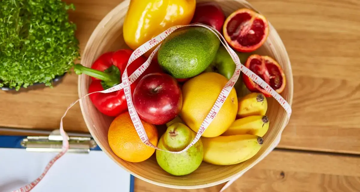 Miska pełna owoców i warzyw, miarka krawiecka. Idealne składniki na zdrowy dieta 500 kcal jadłospis na tydzień.