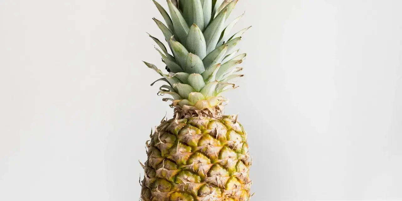 Ananas z zielonymi liśćmi i żółtą skórką. Poznaj jego ananas wartości odżywcze.