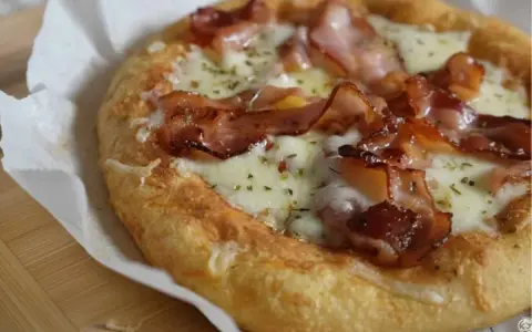 Pyszna keto pizza na drożdżach z chrupiącym boczkiem i ciągnącym serem. Idealna na szybki posiłek.