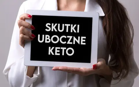 Kobieta w białej bluzce prezentuje tablet z napisem "SKUTKI UBOCZNE KETO".