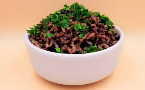 Mielona wołowina z natką pietruszki w białej miseczce. Idealna baza do wielu dań, np. do sosu bolognese. Prosty przepis na wołowinę.