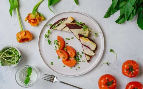 Kolorowe śniadanie na talerzu: kanapka z serem i burakiem, pomidory, kiełki. Idealne na dietę 1800 kcal 4 posiłki.