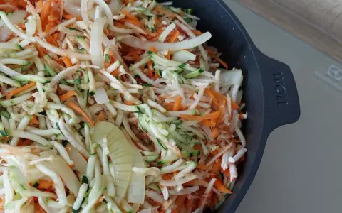 Start przygotowania keto ryby po grecku: starta marchewka, cukinia i cebula w naczyniu.