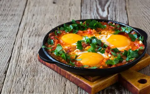 Jajka sadzone w sosie pomidorowym z natką pietruszki, idealne na śniadanie keto. Proste dieta keto przepisy.