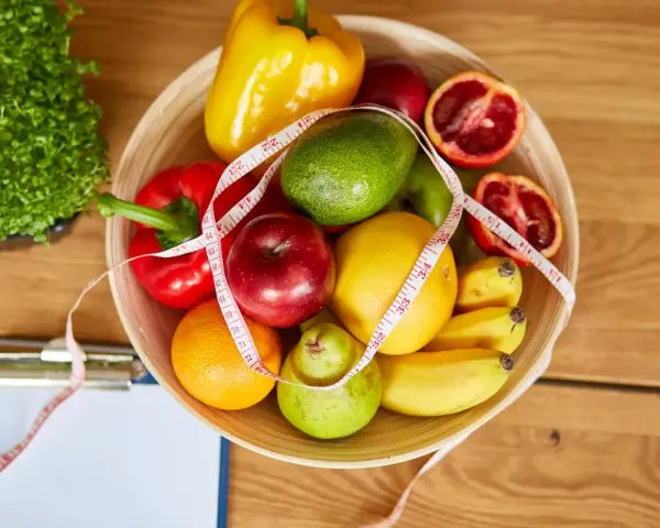Miska pełna owoców i warzyw, miarka krawiecka. Idealne składniki na zdrowy dieta 500 kcal jadłospis na tydzień.