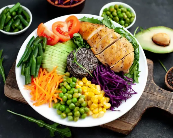 Kolorowa sałatka z kurczakiem, awokado, warzywami i komosą ryżową. Idealna na dietę low carb, z niską zawartością węglowodanów.