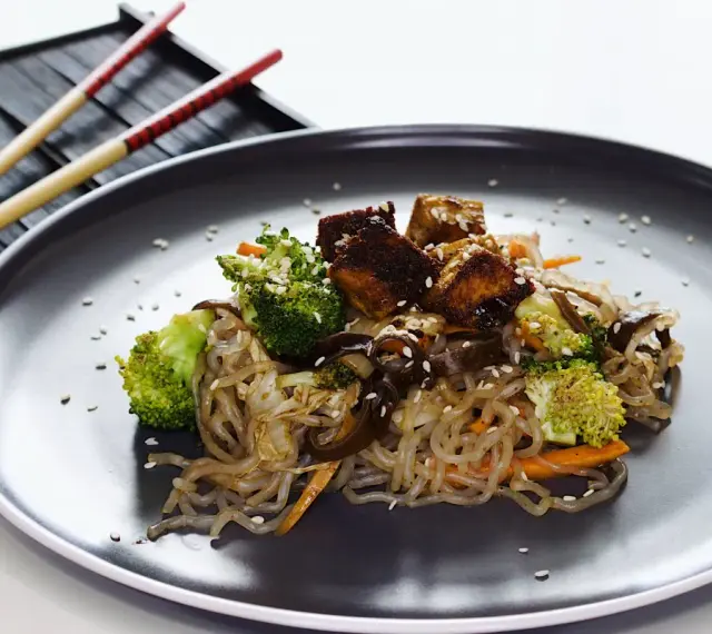 Makaron konjac z warzywami i tofu, posypany sezamem. Inspiracja na zdrowe przepisy.