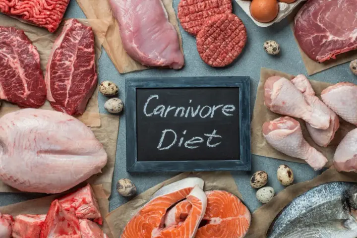 Różnorodne mięsa, ryby i jaja na stole. Tabliczka z napisem "Carnivore Diet" sugeruje potencjalne dieta karniwora efekty.
