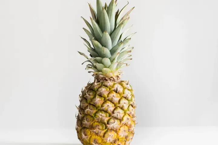 Ananas z zielonymi liśćmi i żółtą skórką. Poznaj jego ananas wartości odżywcze.