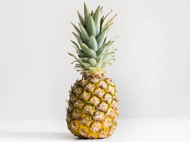 Ananas z zielonymi liśćmi i żółtą skórką. Poznaj jego ananas wartości odżywcze.